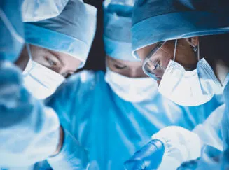 group of doctors looking down in an operatory setting