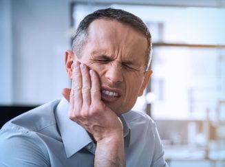 man in pain holding the side of his face